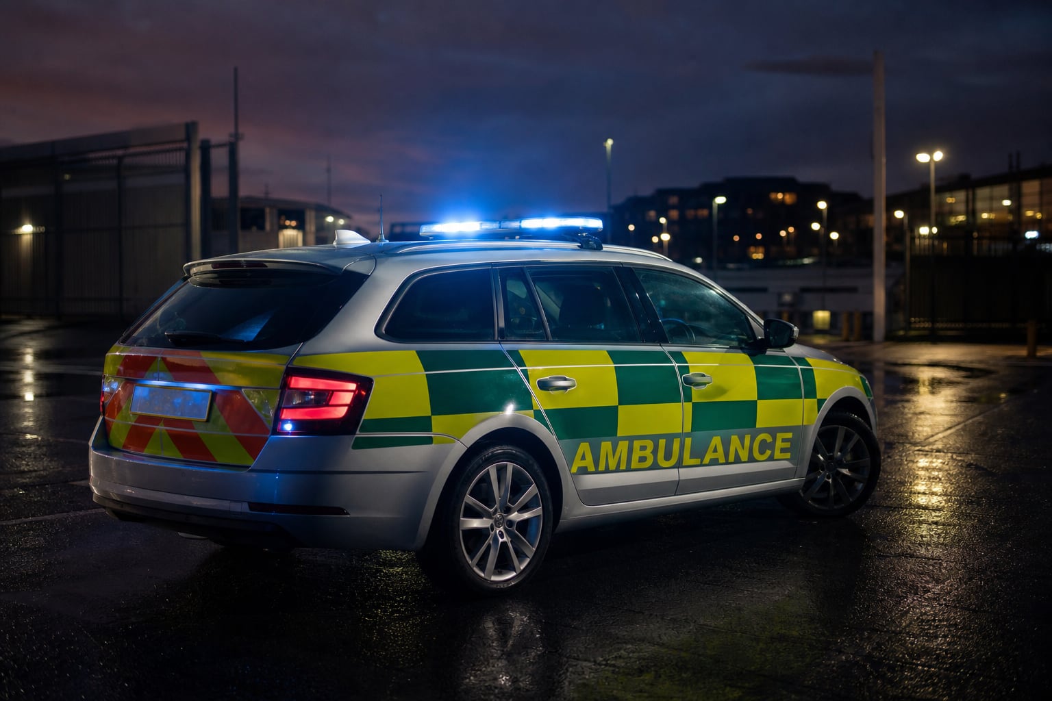 UK ambulance response car with blue lights at dusk